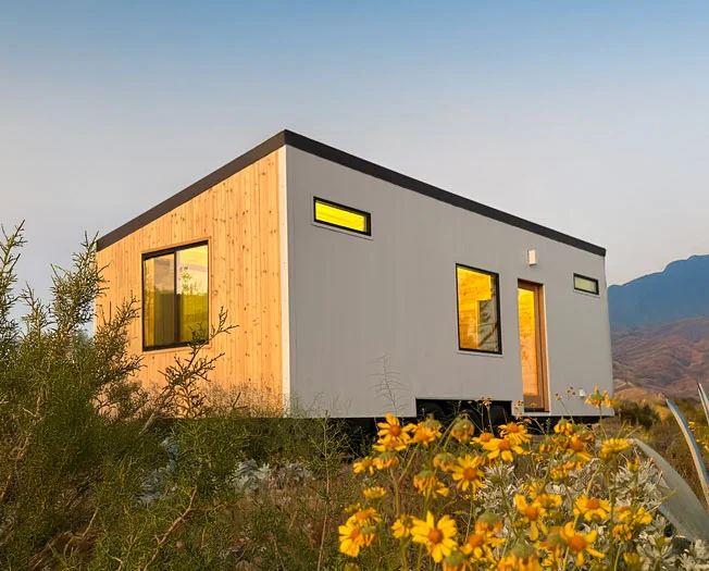 Cahill Works Scandinavian Tiny House with cedar siding, white panels, and mountain backdrop