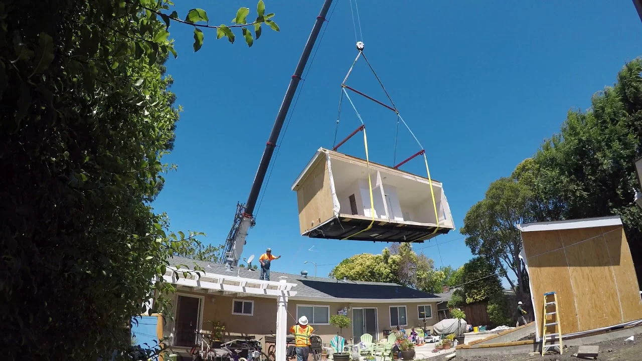 prefabADU modular home module being set by crane during a company tour