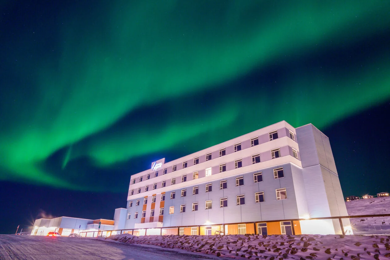 Stack Modular Aqsarniit Hotel and Conference Centre exterior in Iqaluit beneath the aurora