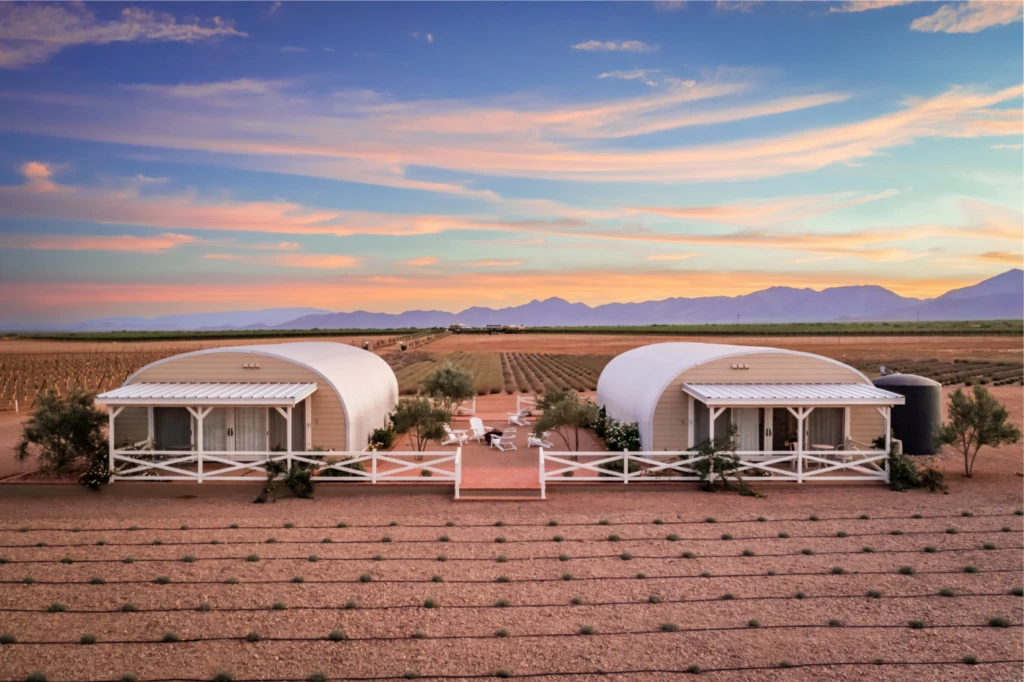 Two corrugated steel arch huts with covered porches at Rhumb Line Vineyard.