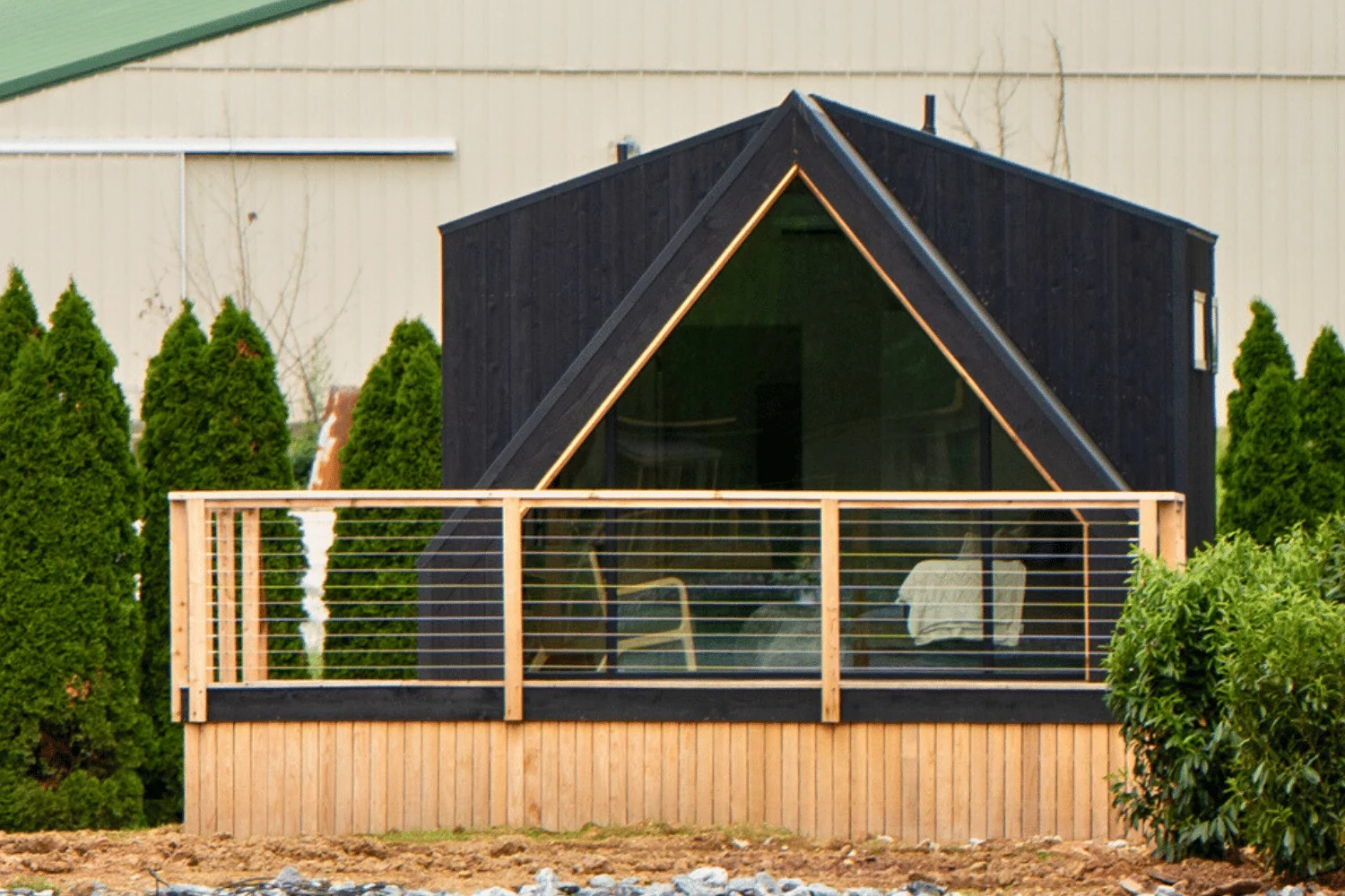 A black A-Frame Studio cabin with a triangular glass front and wood deck at Red Run Resort in New Holland, Pennsylvania.